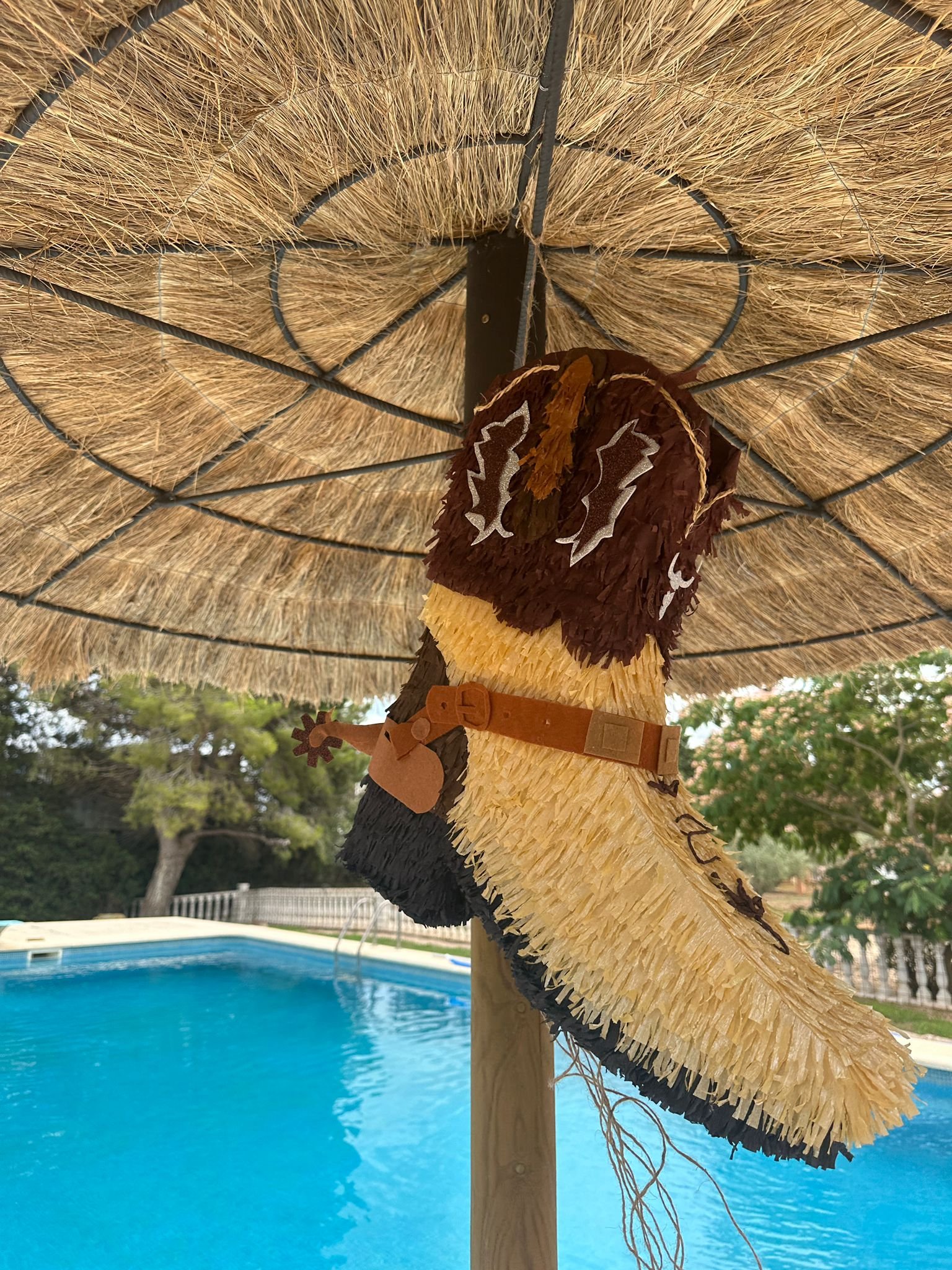 Piñata de bota cowboy colgada en exterior, mostrando tamaño real y detalles