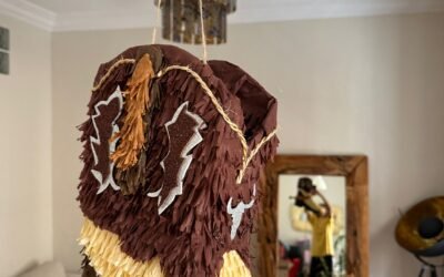 Piñata de bota cowboy vista de cerca, con textura artesanal y papel de seda marrón y beige